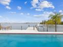 Backyard pool and dock overlooking the water, with outdoor seating and a boat lift at 11549 48Th Ave N, St Petersburg, FL 33708