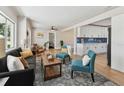 Open-concept living room with modern furniture, bright windows, and an adjacent kitchen area with white cabinetry at 1165 63Rd S Ave, St Petersburg, FL 33705