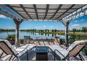 Relax on the patio with a pergola, offering serene lake views and a cozy seating area at 12315 Dora Trail, Parrish, FL 34219