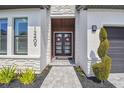 Elegant entrance with double doors, stylish sidelights, manicured landscaping and exterior stone accents at 12409 Gentle Swan Pl, Odessa, FL 33556