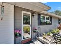 Inviting home entrance with lovely potted plants and a modern glass door at 1655 Owen Dr, Clearwater, FL 33759