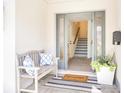 Inviting foyer with a bench, stylish rug, and stairs leading to the upper level at 1725 Massachusetts Ne Ave, St Petersburg, FL 33703