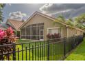 Spacious backyard featuring a screen enclosed patio, iron fence, and well-maintained lawn at 18919 Place Marquette, Lutz, FL 33558