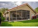 View of screen enclosed patio with outdoor seating and view of backyard at 18919 Place Marquette, Lutz, FL 33558