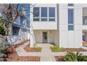 Modern home with a paved path leading to the front door, featuring a minimalist design and manicured landscaping at 2003 Gulf Way, St Pete Beach, FL 33706