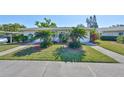 Street view of the home featuring lush landscaping, green grass, and an inviting entrance at 2202 Clubhouse Dr # 174, Sun City Center, FL 33573