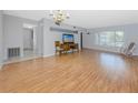 Spacious living room features laminate flooring, a large window, and a vintage chandelier for bright, comfortable living at 2229 Americus W Blvd # 25, Clearwater, FL 33763