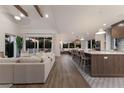 Bright, open-concept living room, dining, and kitchen area with wood floors and neutral furnishings at 311 Spring Ave, Anna Maria, FL 34216