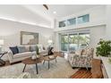 Comfortable living room featuring vaulted ceilings, a sliding glass door and hardwood floors at 3398 Pinnacle S Ct, Palm Harbor, FL 34684