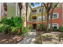 Condominium building with green and orange walls and balconies surrounded by palm trees and plants at 4207 S Dale Mabry Hwy # 3302, Tampa, FL 33611