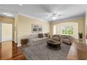 Bright living room with a large arched window, hardwood floors, and cozy neutral-toned furniture at 4207 S Dale Mabry Hwy # 3302, Tampa, FL 33611
