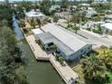 An aerial view showcases the home's waterfront location and extensive dock on a wide canal at 636 Tarawitt Dr, Longboat Key, FL 34228