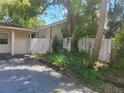 View of the side of the property, showcasing a wooden fence and mature trees in the backyard at 8609 N 11Th St, Tampa, FL 33604