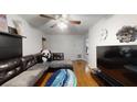 Comfortable living room featuring hardwood floors, a cozy sofa, and minimalist decor on the walls at 8609 N 11Th St, Tampa, FL 33604