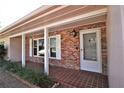 Inviting front porch with brick accents, decorative lighting, and a tiled entryway at 1001 Brookside Dr, Clearwater, FL 33764