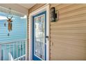 Close-up of front door with glass detailing, modern light fixture, and blue trim at 12312 Lagoon Ln, Treasure Island, FL 33706