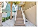Staircase leading up to a blue front door with white railings and decorative rock landscaping at 12312 Lagoon Ln, Treasure Island, FL 33706
