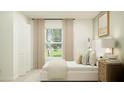 Cozy bedroom with neutral tones, large window and comfortable furnishings at 13174 Goldstone Ct, Wimauma, FL 33598