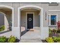 Inviting front porch featuring an arched entryway, decorative wreath, and views of manicured landscaping at 13319 Dorado Shores Ave, Riverview, FL 33579