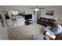 Cozy living room with carpeted floors, comfortable seating, and an adjacent kitchen with stainless appliances at 1345 Springdale St, Clearwater, FL 33755