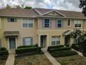 Charming townhome exterior with light beige siding, blue shutters, and neatly trimmed landscaping at 15733 Fishhawk Falls Dr, Lithia, FL 33547