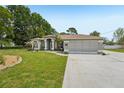 Charming single-story home featuring a well-manicured lawn and an inviting front entrance with beautiful landscaping at 2016 Alameda Dr, Spring Hill, FL 34609