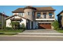 Beautiful two-story home showcasing a stone tower, tile roof, balcony, manicured landscaping, and brick driveway at 21867 Amelia Rose Way, Land O Lakes, FL 34637