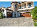 Attractive home with a stone tower, balcony, paver driveway and 3-car garage, and lush landscaping at 21867 Amelia Rose Way, Land O Lakes, FL 34637