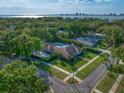 Aerial view of the home showcases a backyard pool with bay and city views beyond at 307 Oleander Rd, Belleair, FL 33756