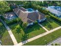 Aerial view of home with lush yard, swimming pool, basketball court and mature palm trees at 307 Oleander Rd, Belleair, FL 33756