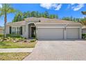 Beautifully landscaped single-story home featuring a three-car garage and a welcoming front entrance at 3321 Mapleridge Dr, Lutz, FL 33558