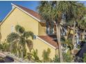 Charming yellow condo exterior featuring lush tropical landscaping and modern architectural details at 3540 42Nd S St # F, St Petersburg, FL 33711