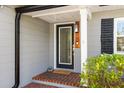 Close up front entryway featuring a black trimmed glass door, grey siding, and brick porch at 3614 S Lois Ave, Tampa, FL 33629