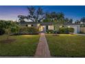 Charming single-story home with well-manicured lawn, walkway, and mature trees under a lovely dusk sky at 3614 S Lois Ave, Tampa, FL 33629