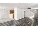 Open floor plan with wood-look flooring, neutral paint, staircase and kitchen with tile flooring at 7350 Lumber Port Dr, Ruskin, FL 33573