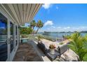Inviting backyard patio area with comfortable seating, lush landscaping, and direct access to the waterfront at 785 Bay Esplanade, Clearwater Beach, FL 33767
