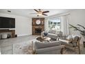 Bright living room featuring a fireplace, stylish furniture, and large windows with natural light at 11467 93Rd St, Largo, FL 33773