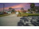 Charming single-story home featuring stone accents, attached garage, and a long driveway at sunset at 1371 Meredith Dr, Spring Hill, FL 34608
