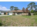 Charming single-story home featuring stone accents, attached garage, and a grass yard at 1371 Meredith Dr, Spring Hill, FL 34608