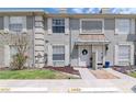Charming townhome with well-maintained lawn, decorative door awning, and neutral color palette at 14053 Notreville Way, Tampa, FL 33624