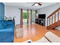 Inviting living room with hardwood floors, bright windows, and adjacent wooden staircase at 14053 Notreville Way, Tampa, FL 33624