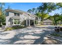 Stately two-story residence with a circular driveway, manicured lawn, and well-maintained landscaping at 15702 Richboro Ct, Tampa, FL 33647