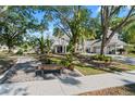 Beautifully landscaped front yard with mature trees, a quaint bench, and a glimpse of the home's facade at 15702 Richboro Ct, Tampa, FL 33647
