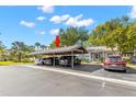 Carport showcasing multiple parking spaces, lush greenery, and an inviting entrance to the well-maintained property at 20 Iris Pl, Oldsmar, FL 34677