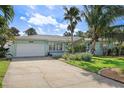Well-maintained light-blue home with a lush front yard, mature landscaping, and a driveway at 2310 Sunrise Se Dr, St Petersburg, FL 33705
