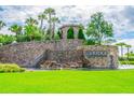 Beautiful community entrance featuring stone waterfalls, lush greenery, and elegant signage at 2632 Tarragona Way, Wesley Chapel, FL 33543