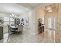 Inviting foyer and dining area featuring tile flooring, modern lighting, and neutral decor at 2632 Tarragona Way, Wesley Chapel, FL 33543