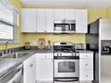 Modern kitchen with stainless steel appliances, white cabinets, and stylish countertops at 2960 59Th S St # 102, Gulfport, FL 33707