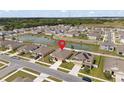 Aerial view of a suburban home located near a pond in a Gathering-friendly neighborhood at 36734 Goffaux Loop, Zephyrhills, FL 33541