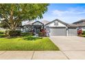 Charming home with a well-manicured lawn, two car garage, and lush landscaping at 3829 Eagleflight Ln, Land O Lakes, FL 34639